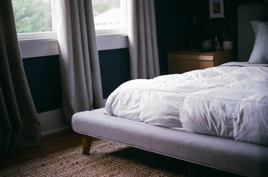 Ein gemachtes Bett mit einer sauberen Gewichtsdecke.